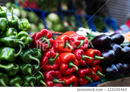 Box is filled with pepper, grocery store display case. 128195463