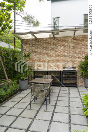 Patio at the backyard of a house with brick wall. Outdoor place for party and BBQ. Patio at the backyard of a house with brick wall. Outdoor place for party and BBQ. 128195892