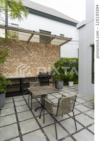 Patio at the backyard of a house with brick wall. Outdoor place for party and BBQ. Patio at the backyard of a house with brick wall. Outdoor place for party and BBQ. 128195894
