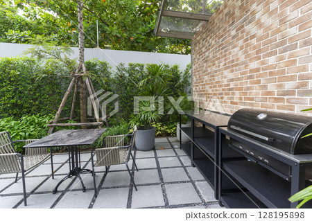 Patio at the backyard of a house with brick wall. Outdoor place for party and BBQ. Patio at the backyard of a house with brick wall. Outdoor place for party and BBQ. 128195898