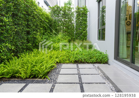 Modern design home garden landscaping. Flower garden and green plant with brick border and pedestrian pathway. 128195938