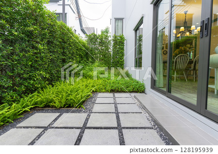 Modern design home garden landscaping. Flower garden and green plant with brick border and pedestrian pathway. 128195939