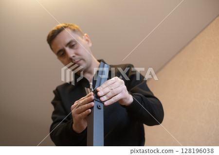 Man assembling furniture at home with his own hands expert in furniture repair and assembly services. Man assembling furniture at home with his own hands expert in furniture repair and assembly services. 128196038