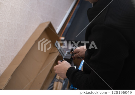 Man repairs and assembles furniture by himself showing professional approach and attention to detail at home. Man repairs and assembles furniture by himself showing professional approach and attention to detail at home. 128196049