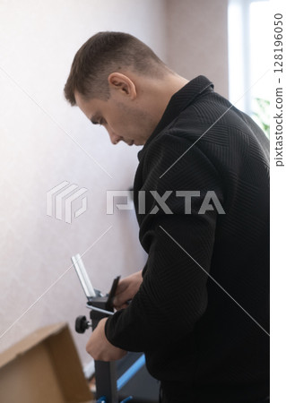 Furniture assembly specialist working at home carefully installing parts creating a functional and organized interior. Furniture assembly specialist working at home carefully installing parts creating a functional and organized interior. 128196050