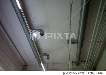 Industrial ceiling with ventilation ducts and fluorescent lights inside brewery Industrial ceiling with ventilation ducts and fluorescent lights inside brewery 128196687