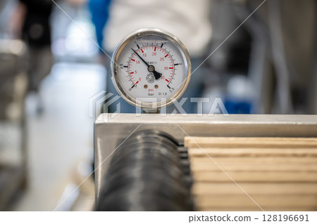 Pressure gauge in craft brewery showing PSI and bar levels on brewing equipment 128196691