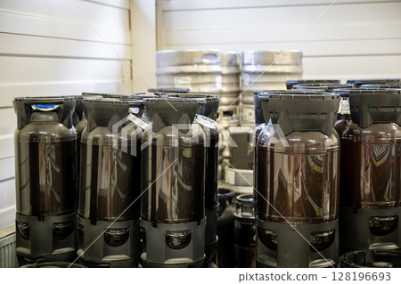 Plastic and metal beer kegs stacked in storage area at craft brewery facility Plastic and metal beer kegs stacked in storage area at craft brewery facility 128196693