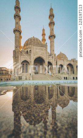 Elegant Architecture Of The Heydar Mosque In Baku At Sunset: Majestic Islamic Landmark With Reflection On Marble Surface And Soaring Minarets 128197113