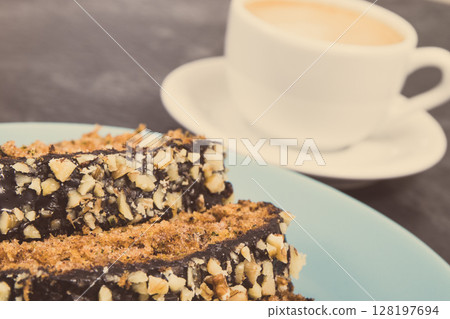 Fresh baked pastry made of zucchini and cup of white coffee. Delicious dessert. Vintage photo Fresh baked pastry made of zucchini and cup of white coffee. Delicious dessert. Vintage photo 128197694