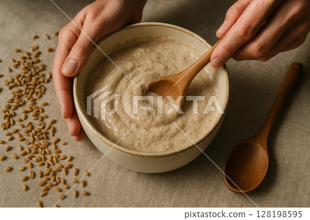 Person mixing fresh homemade creamy grain porridge in ceramic bowl with wooden spoon, healthy natural breakfast preparation, AI Generative 128198595