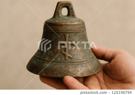 Antique orthodox church bell held by hand with traditional cross symbol, representing religious heritage and spiritual tradition, AI Generative 128198794