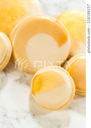 A collection of sugar cookies decorated with smooth royal icing and hand-painted gold accents. These elegant cookies are perfect for weddings, parties, and festive celebrations, adding a touch of 128199257