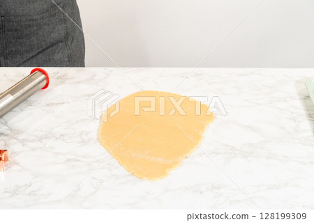 Sugar cookie dough rolled out evenly, ready for shaping. 128199309