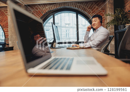 A Young Professional Engaged in Remote Work Within a Contemporary Office Environment 128199561