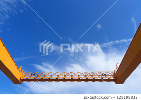 藍天白雲下的黃色龍門吊起重機 128199832