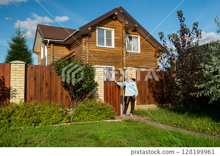 A Woman Standing at the Entrance of Her Home in a Beautiful and Picturesque Neighborhood 128199961