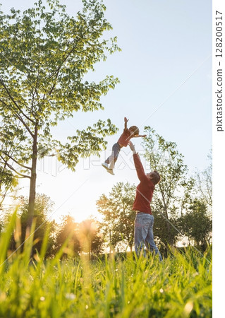 Father tossing Son High in Sunny Park Father tossing Son High in Sunny Park 128200517