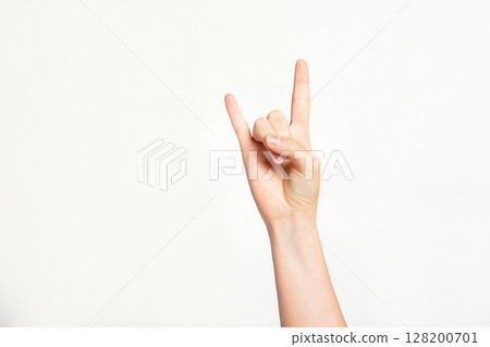 Woman's hand gesturing rock and roll, heavy metal, devil horns gesture or I love you on light grey background. 128200701