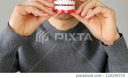 Person holding a tooth model 128200719