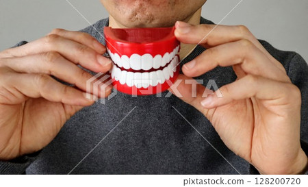 Person holding a tooth model 128200720