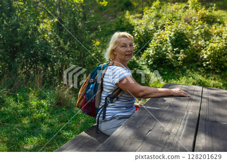 Senior Woman Resting at Forest Table on Hike 128201629