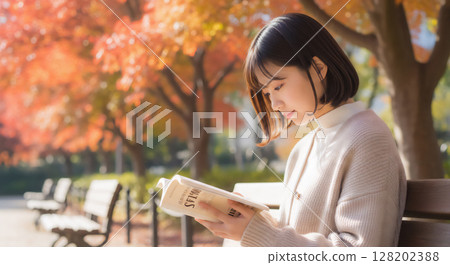 Portrait of a woman enjoying reading in an autumn park 128202388