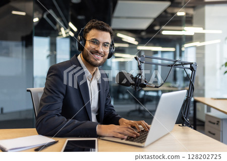 Portrait of successful businessman teacher mentor. Man in business suit records audio course podcast, about finance and investing. Blogger in headphones and uses professional microphone. 128202725