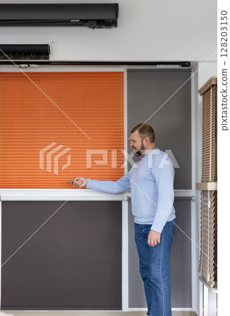 Man Demonstrating Motorized Blinds in Modern Window Treatment Showroom Man Demonstrating Motorized Blinds in Modern Window Treatment Showroom 128203150