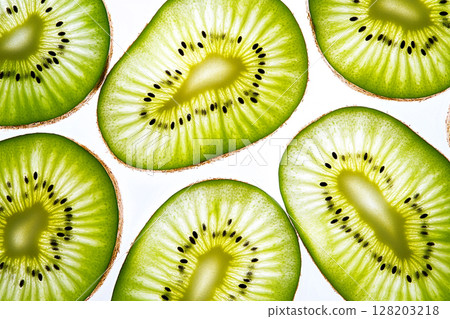 A close-up view of numerous vibrant green kiwi slices, showcasing their intricate patterns of seeds and fibrous texture against a white background. 128203218