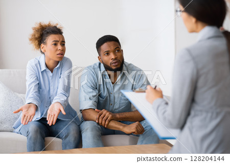 Disagreement In Relationship. Black Couple Discussing Family Issues With Psychologist Sitting On Couch Disagreement In Relationship. Black Couple Discussing Family Issues With Psychologist Sitting On Couch 128204144