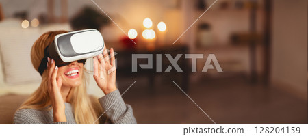 Virtual Reality. Excited Blonde Girl Using VR Headset Playing Videogame At Home. Selective Focus Virtual Reality. Excited Blonde Girl Using VR Headset Playing Videogame At Home. Selective Focus 128204159