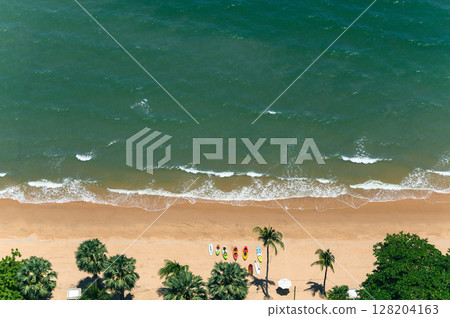 Above view of Pattaya beach in the summer season. High angle shot aerial of beautiful tropical sea with soft waves. Above view of Pattaya beach in the summer season. High angle shot aerial of beautiful tropical sea with soft waves. 128204163