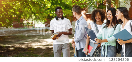 Portrait Of Smiling International Students Standing Outdoors At Campus Courtyard After Classes 128204206