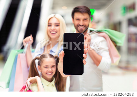 Shopping App. Happy Family Showing Blank Smartphone Screen Spending Time In Mall. Mockup, Shallow Depth Shopping App. Happy Family Showing Blank Smartphone Screen Spending Time In Mall. Mockup, Shallow Depth 128204298