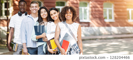 University Community. Multiethnic group of students standing near college building, posing at camera and smiling 128204466