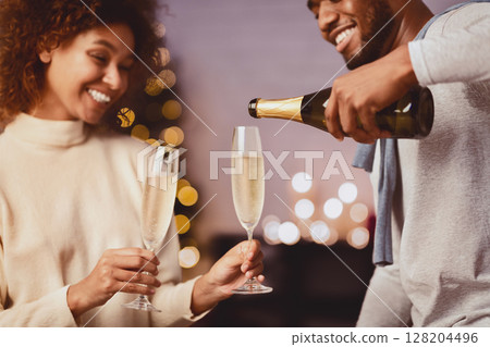 Celebrate Christmas together. Man pouring champagne into glasses 128204496