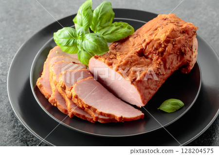 Smoked ham with basil on a black plate. Smoked ham with basil on a black plate. 128204575