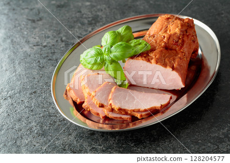 Delicious smoked ham with basil on a metal tray. 128204577