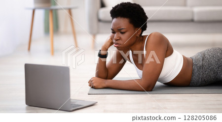 Exhausting Training. African Woman Exercising At Laptop Tired After Online Workout Watching Fitness Video Lying On Floor At Home. Sporty Lifestyle And Weight Loss Burnout Concept Exhausting Training. African Woman Exercising At Laptop Tired After Online Workout Watching Fitness Video Lying On Floor At Home. Sporty Lifestyle And Weight Loss Burnout Concept 128205086