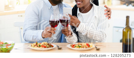 Millennial Couple's Lifestyle. Young Black Lovers Taking Photos On Smartphone While Having Date At Home, Happy African American Couple Drinking Red Wine And Enjoying Tasty Spaghetti, Free Space 128205273