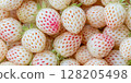 White pineberry strawberries , top view. Pineberry or Hula Berry a hybrid strawberry with a pineapple flavor white flesh and red seeds 128205498
