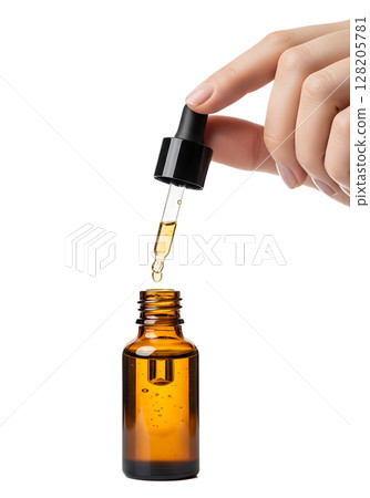 Hand with dropper dispensing serum from small brown glass bottle, skincare routine, isolated on transparent background, beauty treatment 128205781