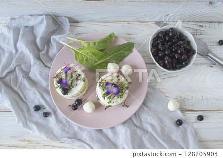 Vegetarian appetizer with cucumber slices, microgreens and feta cheese garnished with fresh purple flowers. Vegetarian appetizer with cucumber slices, microgreens and feta cheese garnished with fresh purple flowers. 128205903