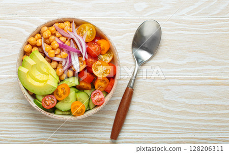 Vibrant vegetarian chickpea salad with fresh vegetables in ceramic bowl top view 128206311