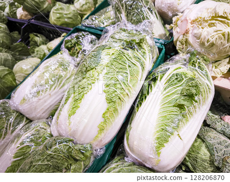 Freshly wrapped napa cabbage displayed in a grocery store showcasing vibrant green leaves and crisp texture, ideal for healthy recipes and cooking inspiration concept Freshly wrapped napa cabbage displayed in a grocery store showcasing vibrant green leaves and crisp texture, ideal for healthy recipes and cooking inspiration concept 128206870