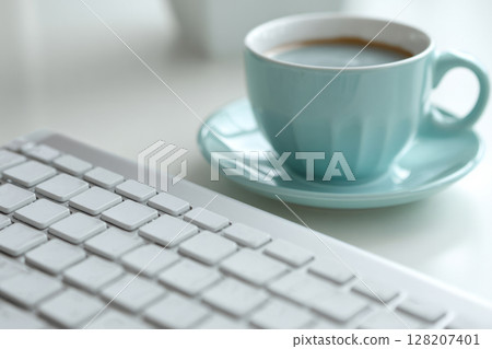 Computer keyboard and coffee cup on white desk 128207401