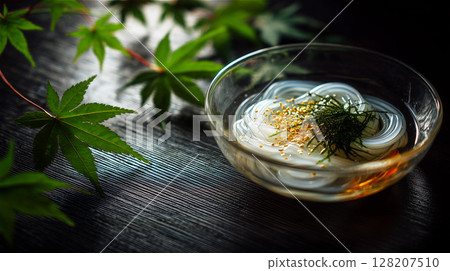 黑色桌上的玻璃碗裡盛著涼粉,用綠色楓葉點綴,是清爽的日本夏季美食 黑色桌上的玻璃碗裡盛著涼粉,用綠色楓葉點綴,是清爽的日本夏季美食 128207510