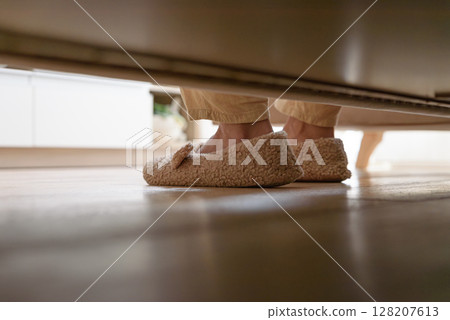 Woman sitting on bed and put on feet into soft plush warm slippers. Soft focus Woman sitting on bed and put on feet into soft plush warm slippers. Soft focus 128207613