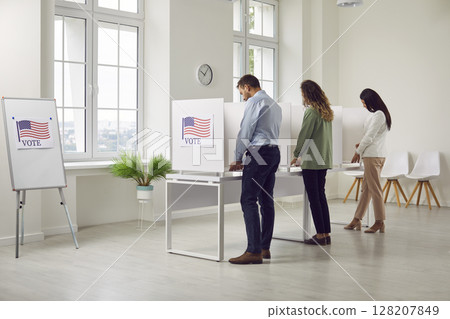 People standing back at vote center in voting booth with usa flags on election day. 128207849